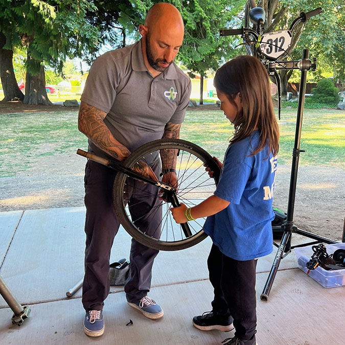 Azus shares bike maintenance with a rider. 