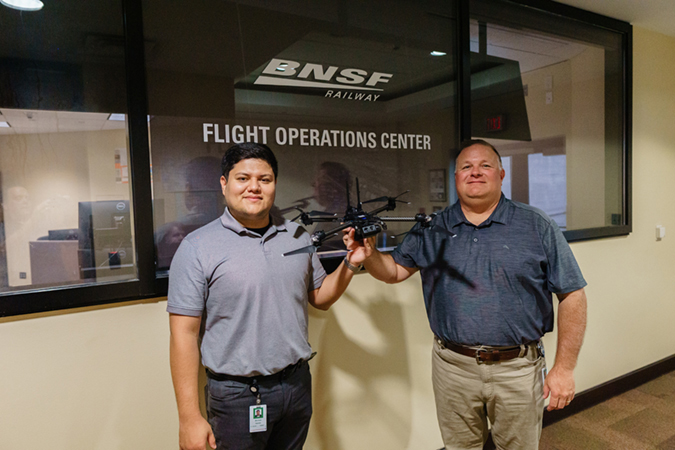 Technology Services Manager Michael Ibanez, left, and Technology Services Director John Martin with a drone outside the Flight Operations Center