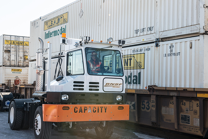 A BNSF hostler next to J.B. Hunt containers